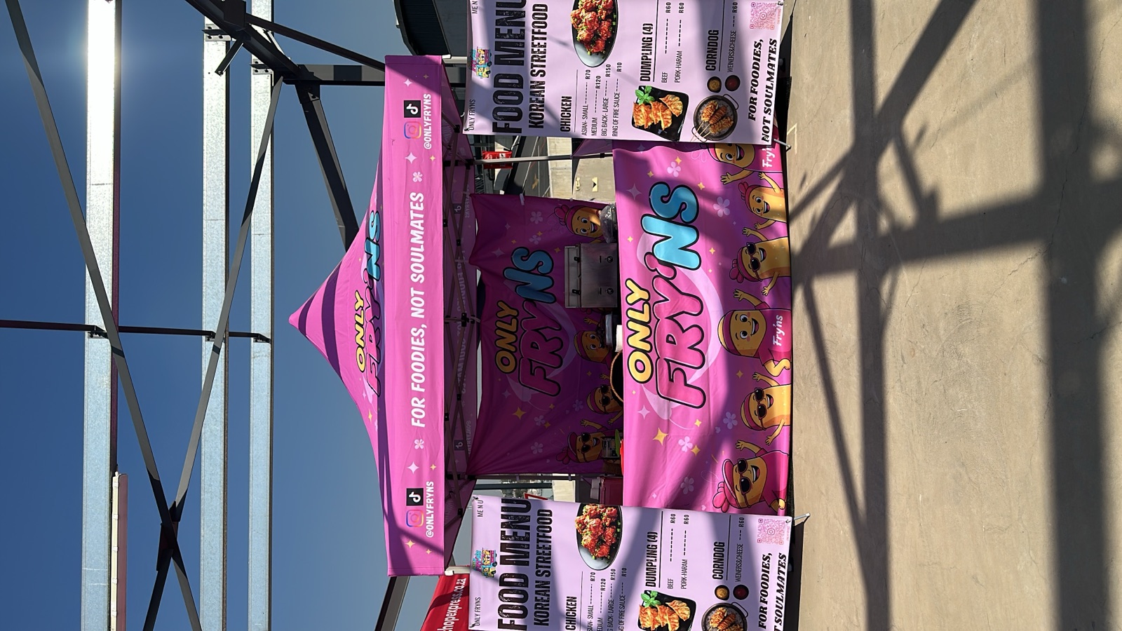 The pink ONLY FRY'NS gazebo set up at a market with menu banners either side